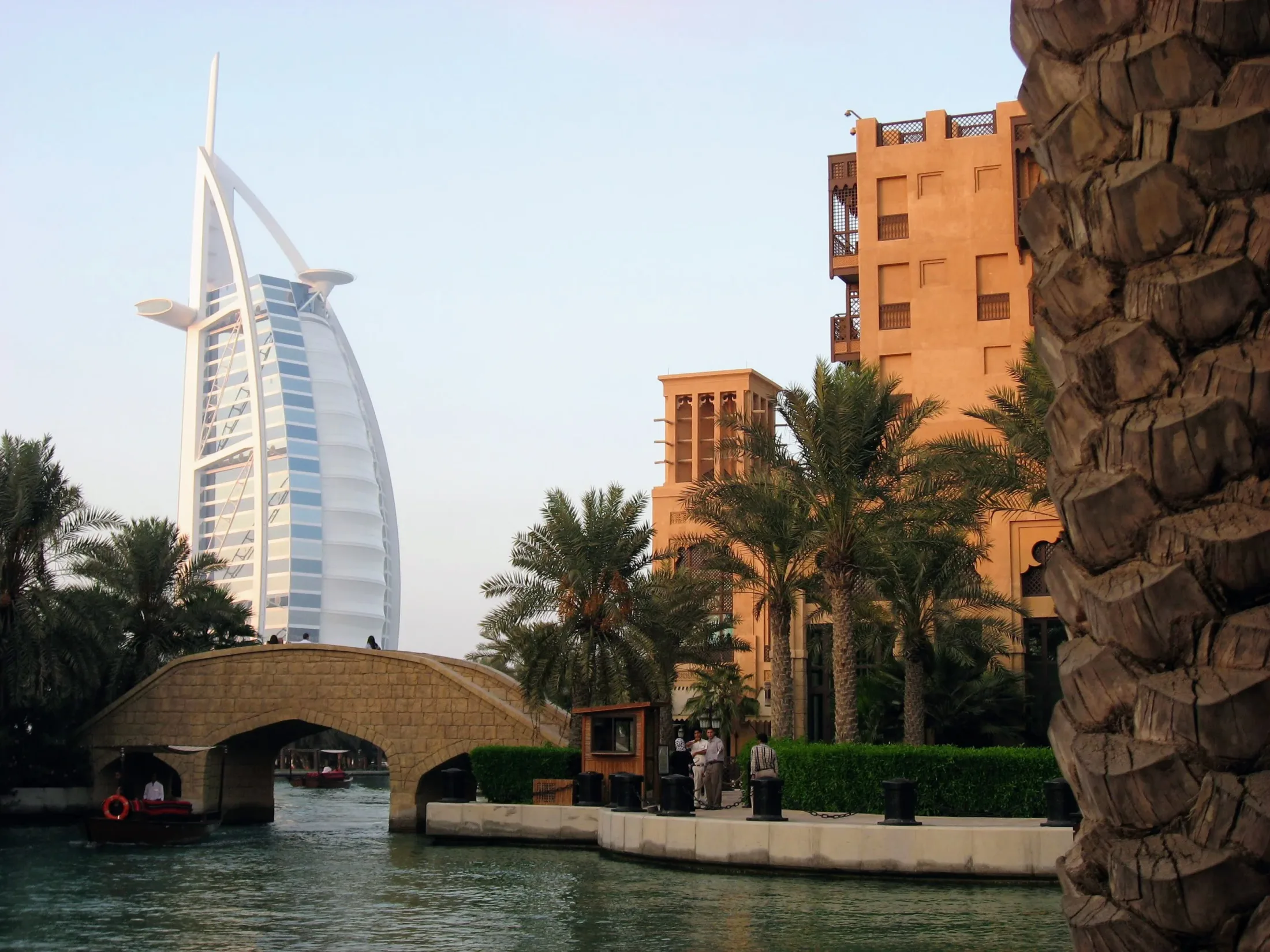The Burj Al Arab and Dubai palms beside a canal.