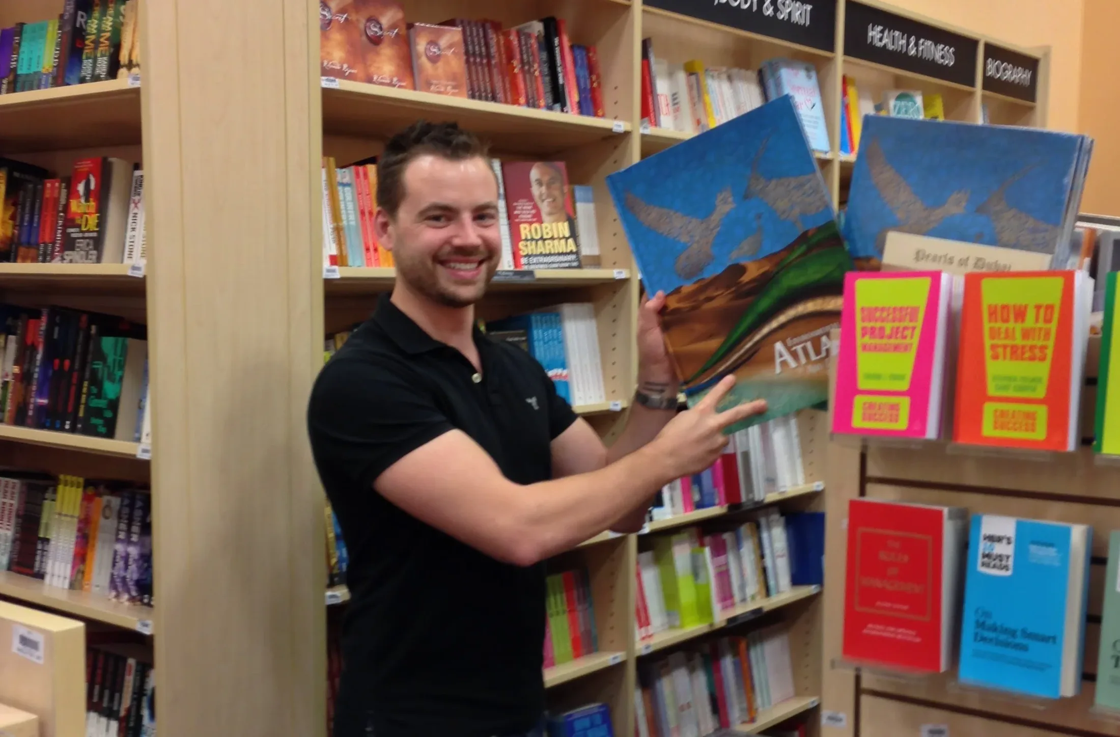 Keith Parker holding an illustrated children’s book in a bookstore.