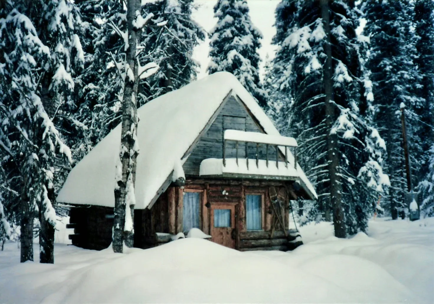 A snow-covered cabin and a winter road in Alaska.
