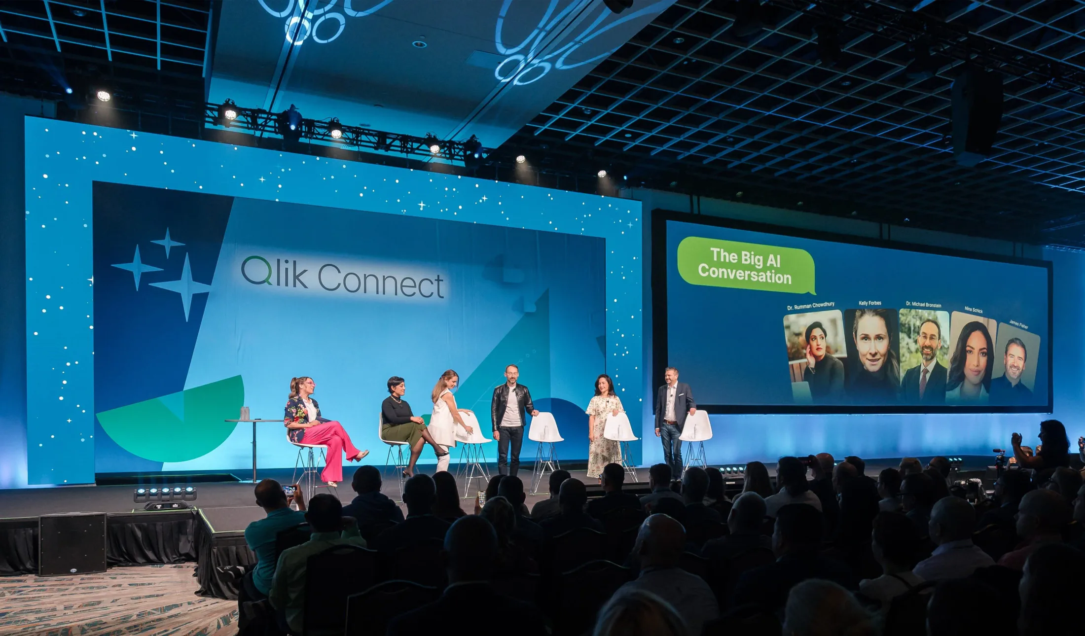 Qlik Connect stage with speakers and an AI conversation screen.